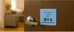 A 消える (kieru, to disappear/go out) verb sticker on an interior door beside the handle