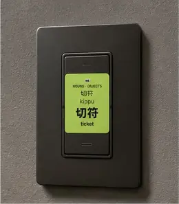 A 切符 (kippu, ticket) vocabulary sticker on a dark wall light switch