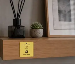 A 店 (mise, shop/store) vocabulary sticker on a wooden shelf next to a reed diffuser and succulent