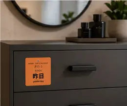 A 昨日 (kinou, yesterday) vocabulary sticker on a black dresser drawer under a round mirror