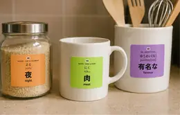 JLPT vocabulary stickers on a kitchen jar, mug, and utensil crock: 夜 (yoru, night), 肉 (niku, meat), and 有名な (yuumei[na], famous)