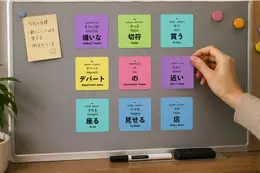 JLPT vocabulary stickers on a whiteboard, including 嫌いな (kirai[na], disliked), 切符 (kippu, ticket), and 買う (kau, to buy)